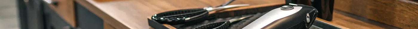 A collection of professional hair trimmers on a barber's workstation.