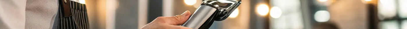 BaBylissPRO Barberology cordless metal double foil shaver held by a barber.