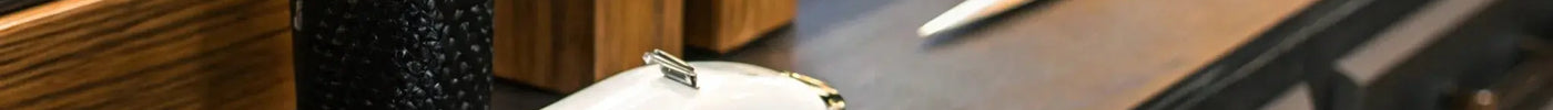 A clipper and blade prepared for sharpening with tools on a barber workstation.