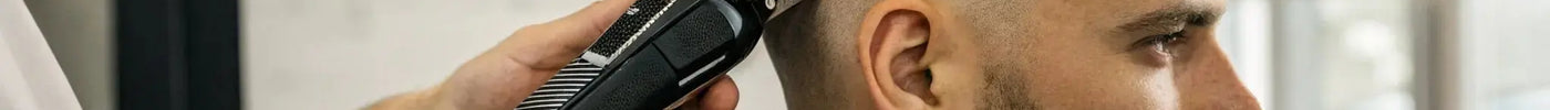 A barber demonstrates how to use magnetic clipper guards for a fade.