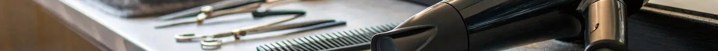 Professional barber hair dryer with a comb and scissors on a salon counter.