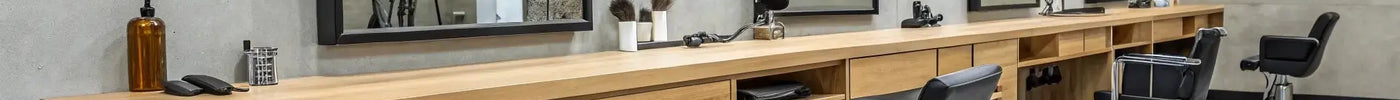 A modern barber station featuring a black organizer with tools on a wooden countertop.