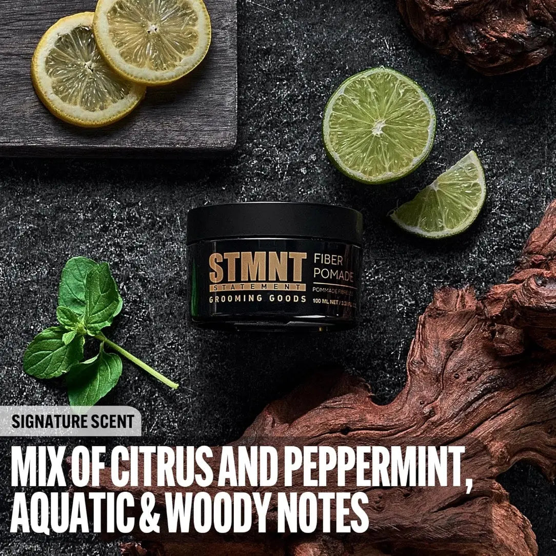 Stimnt Fiber Pomade jar with citrus and peppermint elements on a dark background