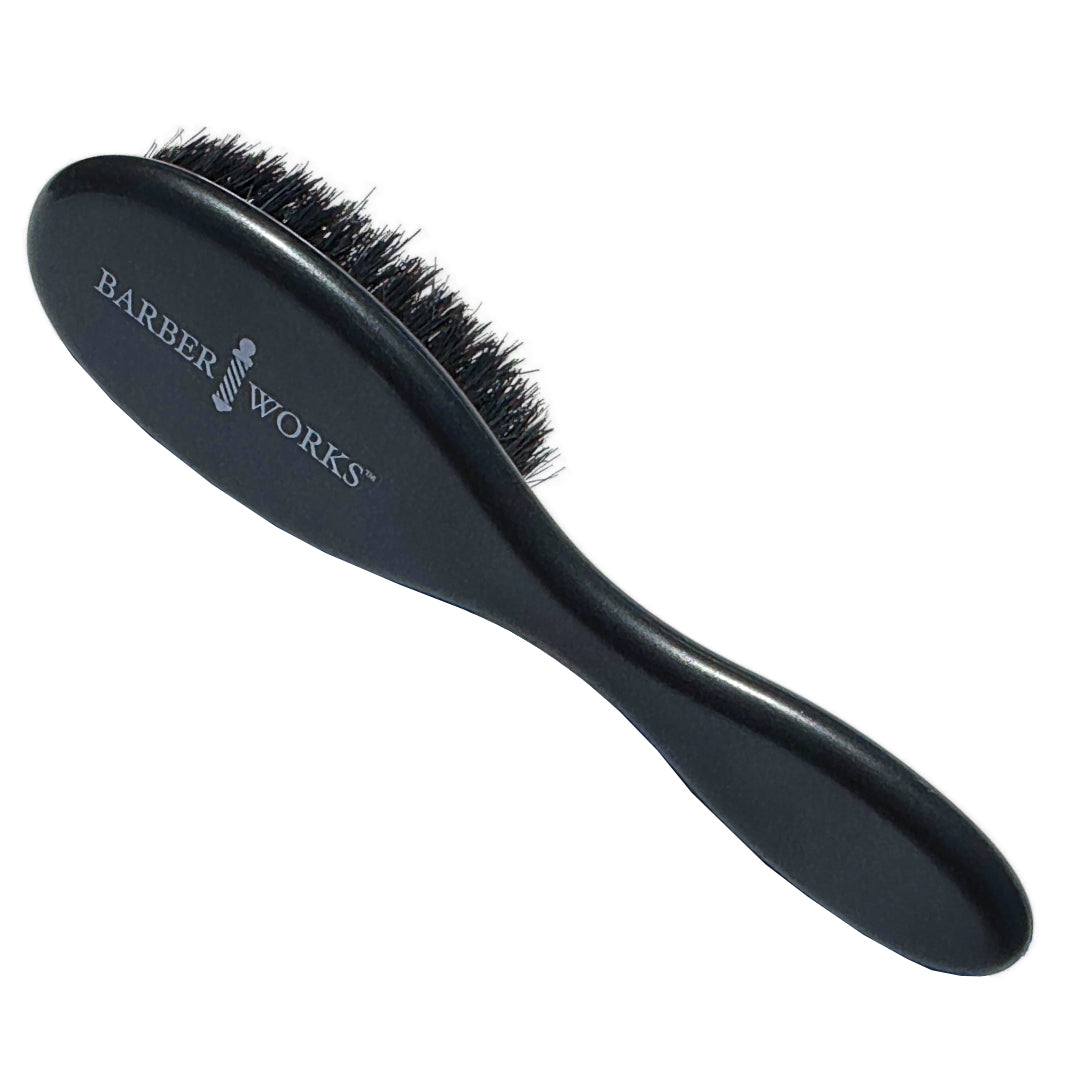 A barber uses the Barber Works Fade Cut Brush to dust off loose hair during a fade haircut.