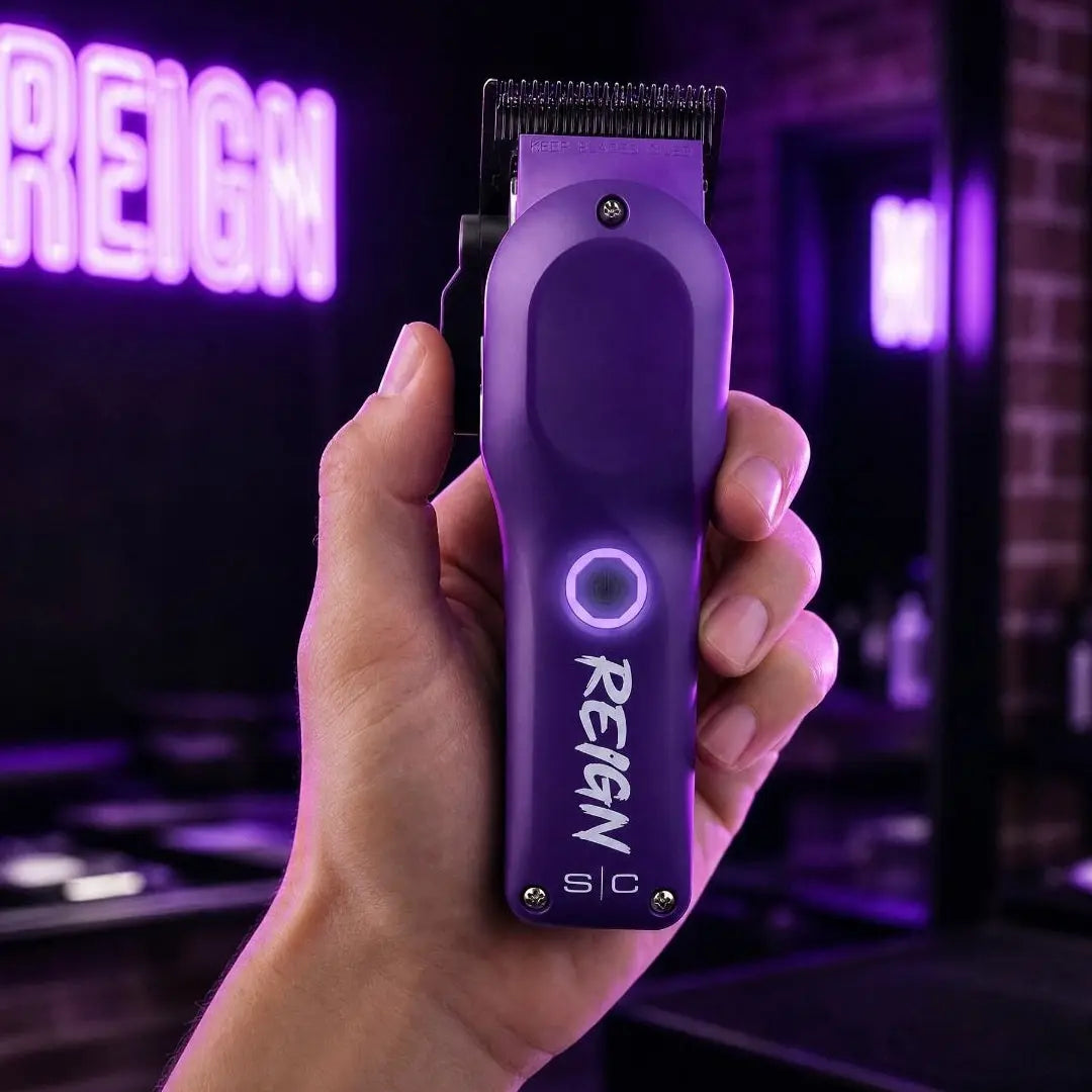 stylecraft Purple hair trimmer with 'Reign' branding held in a hand against a dark background with neon lights.