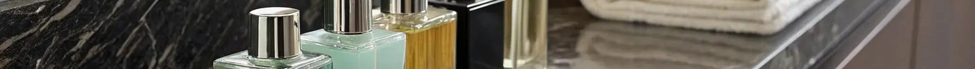 Bottles of the best after shave cologne for barbers on a marble countertop with towels and a brush.