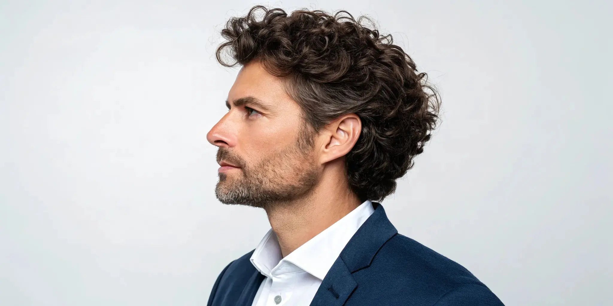 Man in profile with a modern curly cut, one of many popular hair styles for men.