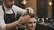 Working barber applying hair gel to a client's styled hair during a barbershop appointment