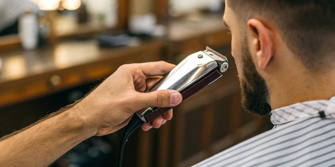 A person changing the blade on an Andis AGC 2 speed clipper.
