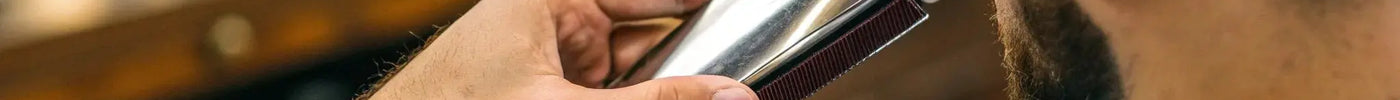 A person changing the blade on an Andis AGC 2 speed clipper.