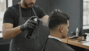 Barber applying spray on hairline enhancement with a card for controlled application