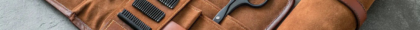 A compact barber travel kit with shears and combs in a roll-up case.