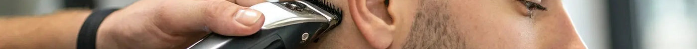 A barber uses a clipper with a fade blade to create a precise skin fade.