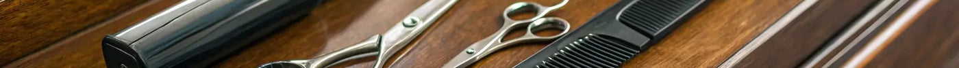 A complete professional barber tool kit with clippers, scissors, and combs laid out.