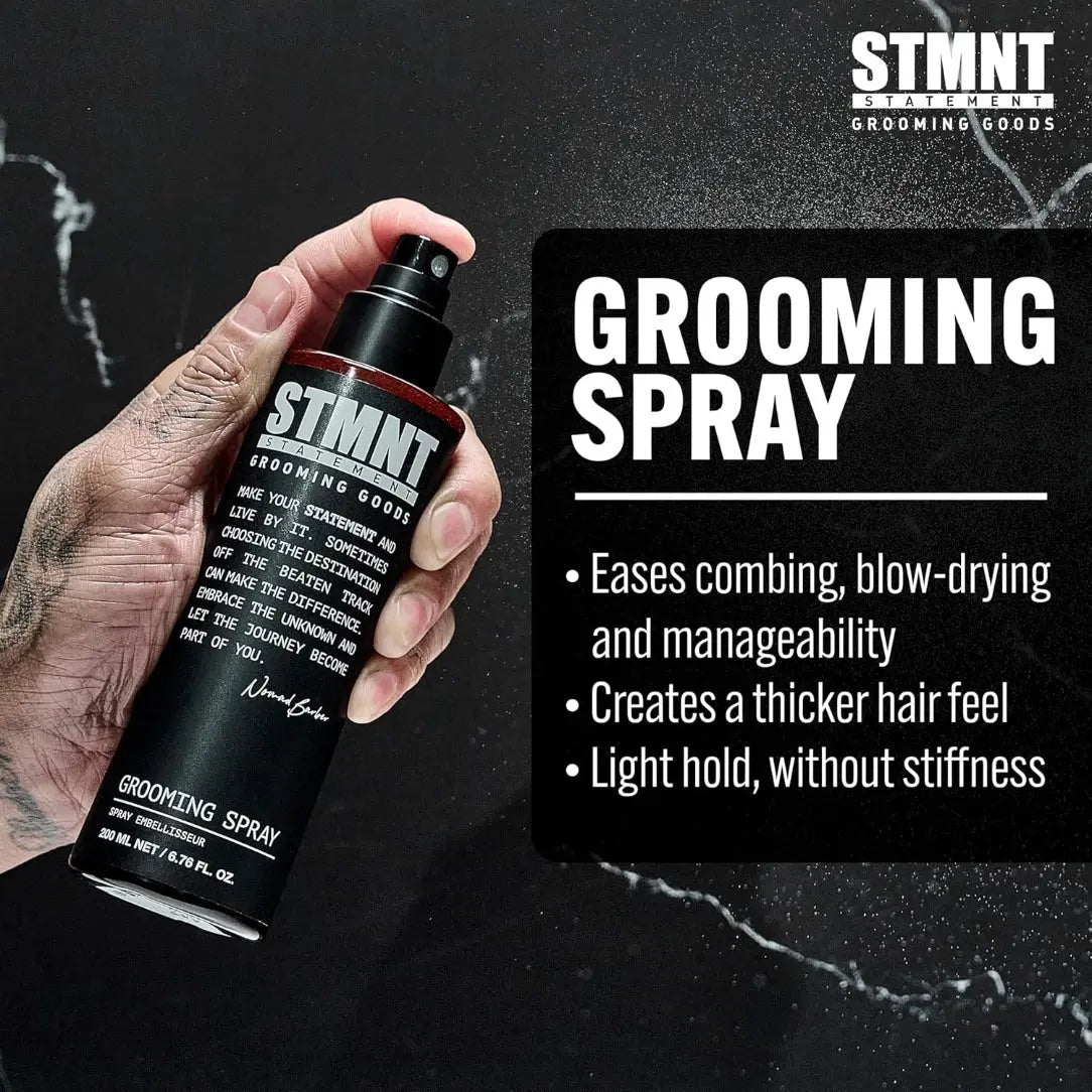 Hand holding a STMNT  grooming spray bottle with product details on a black background