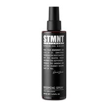 STMNT Black grooming spray bottle with white text on a white background