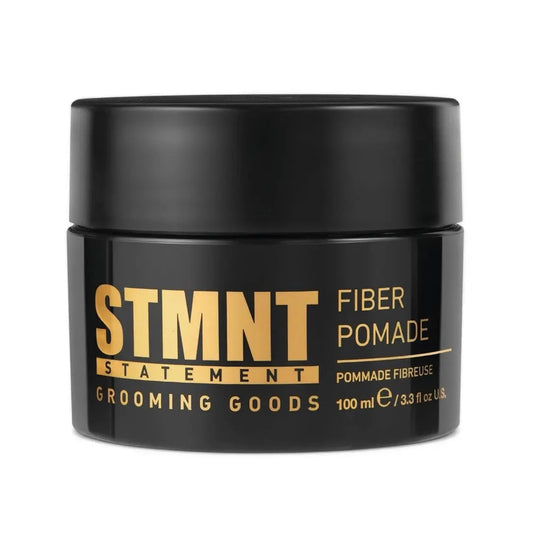 Black jar of STMNT Fiber Pomade with gold text on a white background