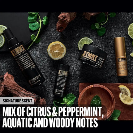 STMNT products with citrus and peppermint on a dark surface