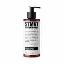 Bottle of STMNT Grooming Goods conditioner on a white background