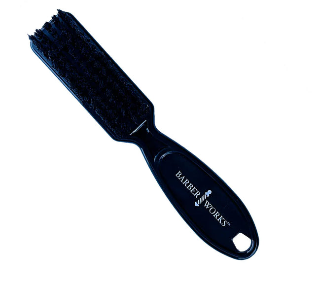 A black hair clipper brush with the brand 'Barber Works' inscribed on the handle.