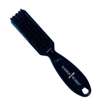 A black hair clipper brush with the brand 'Barber Works' inscribed on the handle.