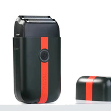 Black and red electric shaver on a white background