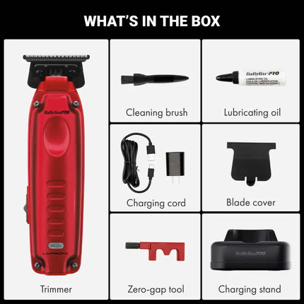 Box contents graphic for a Babyliss Pro red electric hair trimmer, showing the trimmer, cleaning brush, lubricating oil, charging cord, blade cover, zero-gap tool, and charging stand on a white background with a black header reading WHAT'S IN THE BOX.