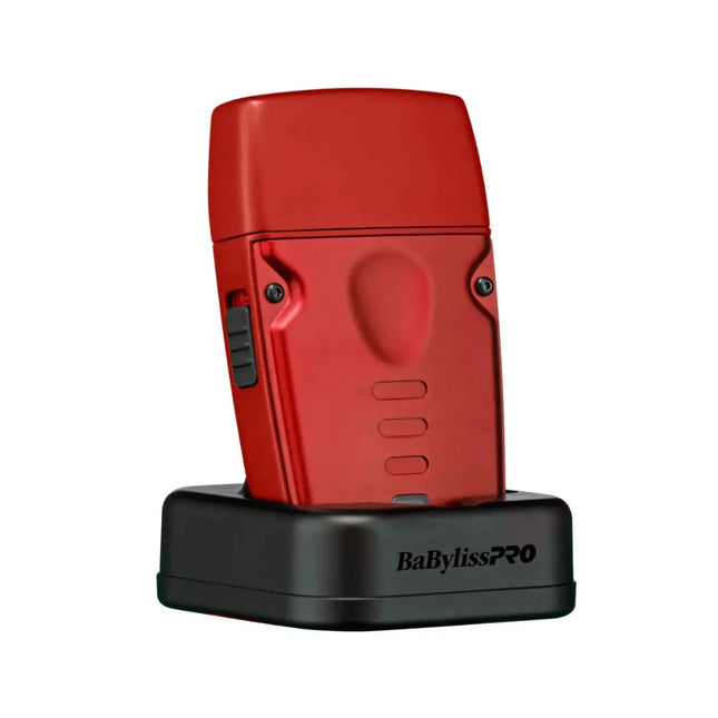 A red BaBylissPRO hair straightener standing upright on a black charging dock against a plain white background.