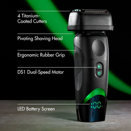 A black and green Babylisspro tomb45 Shaver dual-speed electric shaver standing upright on a dark studio background with feature callouts and white text listing materials and components.