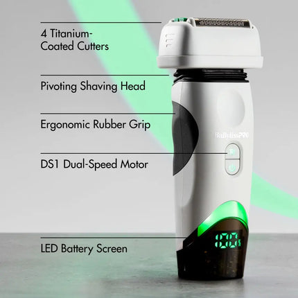 A white and black babyliss electric shaver with green LED accents, shown with callout text listing features such as titanium-coated cutters, a pivoting shaving head, ergonomic rubber grip, DS1 dual-speed motor, and LED battery screen.