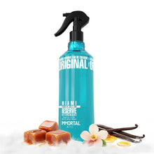 Blue spray bottle labeled 'Original' with vanilla beans and flowers on a white background