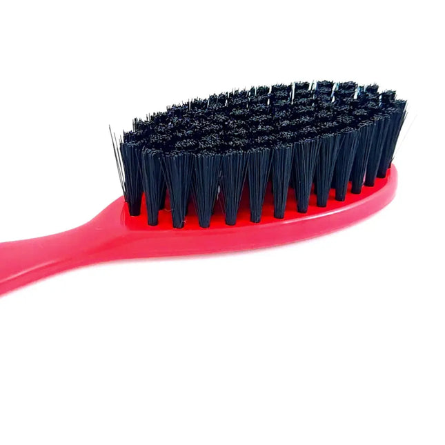 A close-up of a hairbrush showing a bright pink handle and black bristles on a plain white background.