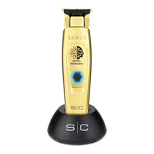 Saber Gold hair trimmer with black stand on a white background