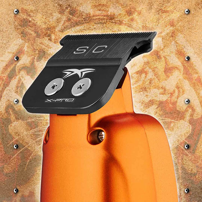 Close-up of an StyleCraft Saber Professional Hair Trimmer – Limited Edition Orange engraved 'S/C' and 'X-PRO' branding, set against a textured metallic background.