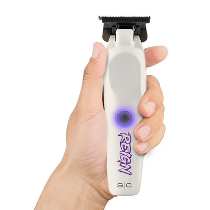 Hand holding a white hair trimmer with purple logo on a white background