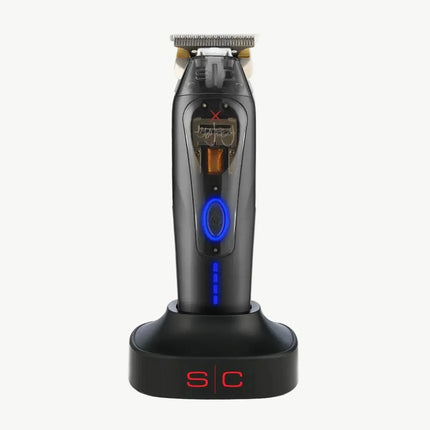 A black cordless electric shaver with blue LED accents, standing upright on a matching black charging dock with red 'S/C' lettering, set against a plain off-white background.