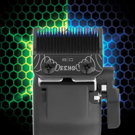 A close-up of a black hair clipper with silver metal blades and decorative claw motifs on the front plate, shown against a dark background with glowing green and blue hexagonal patterns.