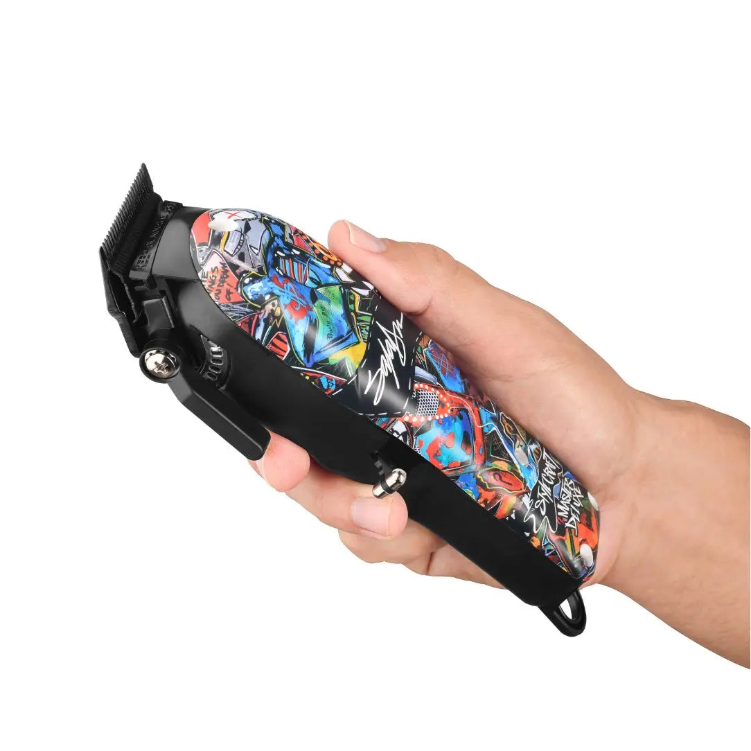 Hair clipper with colorful design held in a hand against a white background