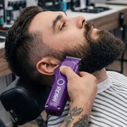 stylecraft Man getting a beard trim with a purple Remington trimmer in a barbershop setting.