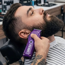 stylecraft Man getting a beard trim with a purple Remington trimmer in a barbershop setting.