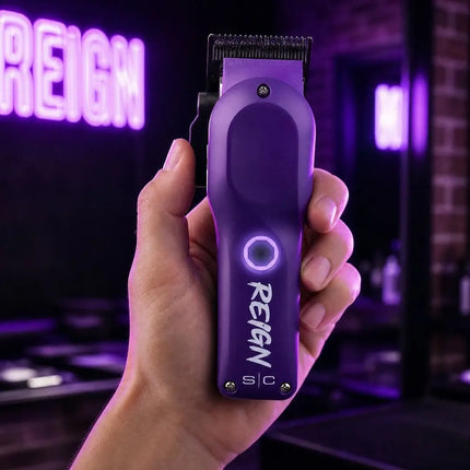 stylecraft  Purple hair trimmer with 'Reign' branding held in a hand against a dark background with neon lights.
