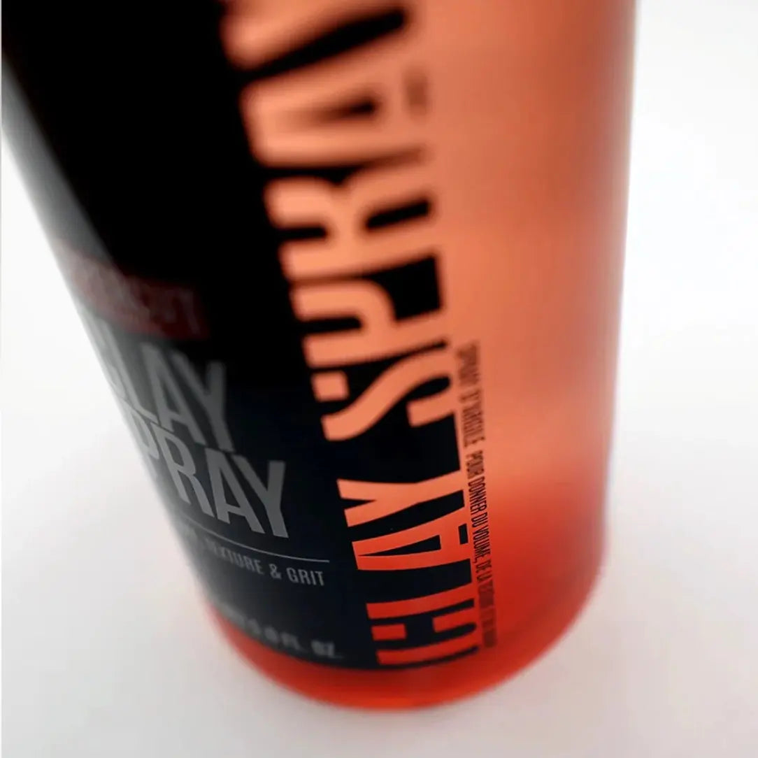 Bottle of hair spray with black and orange label on a white background
