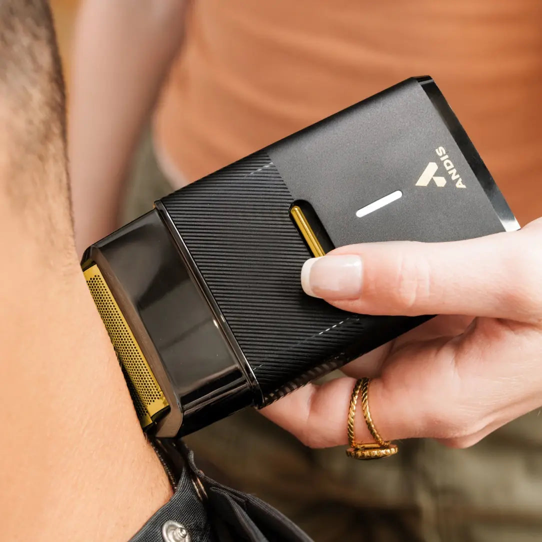 Andis ProFoil Plus II shaver held by a person with a blurred background