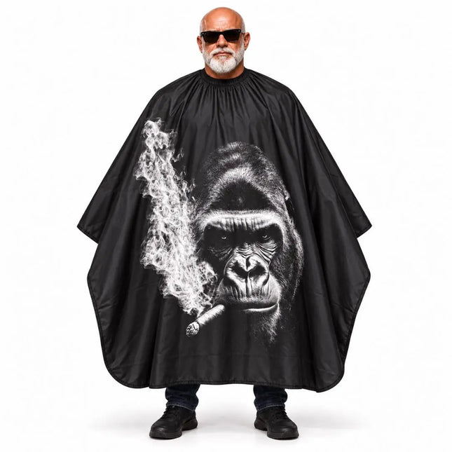 A buybarber.com man wearing a black barber cape with a large black-and-white gorilla graphic holding a cigarette, standing against a plain white background.